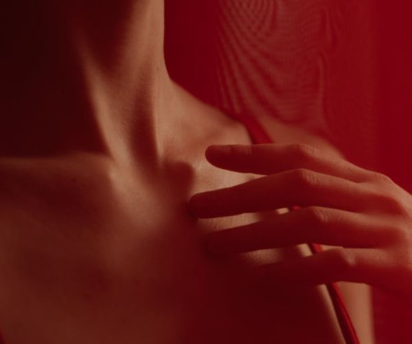 Close-up of a person's chest rising with a deep breath, with abstract light effects.